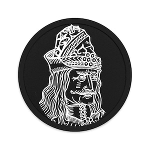 Può includere: Toppa ricamata in bianco e nero di Vlad l'Impalatore, una figura storica, che indossa una corona e una lunga barba. La toppa è circolare e ha uno sfondo nero.