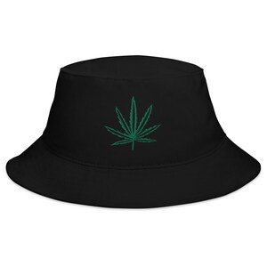 May include: A black bucket hat with a green marijuana leaf embroidered on the front.