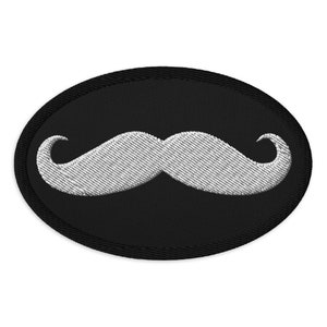 Broderad lapp med klassiskt styrets mustaschmönster