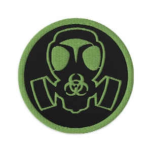 May include: Green and black embroidered patch featuring a gas mask with a biohazard symbol. The patch is circular and has a green border.