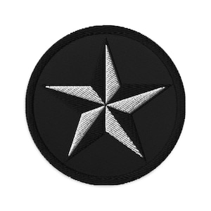 May include: A black and white embroidered patch with a five-pointed star in the center. The star is white with a black outline and is surrounded by a black circle.