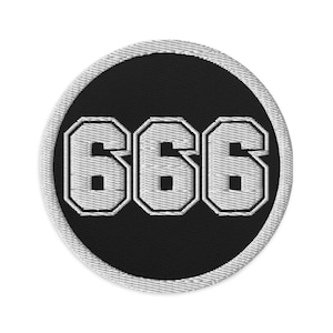 Puede incluir: Parche bordado con el número "666" en blanco, en una fuente en bloque. Los números están sobre un fondo circular negro, con un borde gris claro.