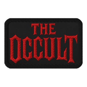 Puede incluir: Parche rectangular negro con las palabras "THE OCCULT" bordadas en rojo con letras góticas. El parche tiene un borde negro y una apariencia texturizada.