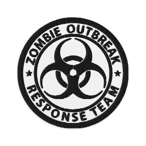 Puede incluir: Parche bordado en blanco y negro con un símbolo de riesgo biológico y el texto "Zombie Outbreak Response Team".