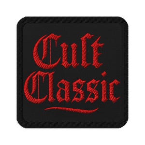 Puede incluir: Un parche bordado cuadrado negro con las palabras "Cult Classic" en letras góticas rojas. El parche tiene un borde negro y está diseñado para ser cosido en ropa o accesorios.