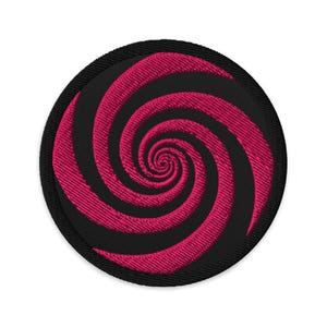 Op de afbeelding: Ronde, zwarte geborduurde patch met een opvallend roze spiraalontwerp. De spiraal staat centraal en contrasteert sterk met de zwarte achtergrond. Geschikt voor het aanbrengen op kleding of accessoires.