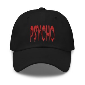 以下が含まれることがあります： 赤い「PSYCHO」の文字が刺繍された黒い野球帽。文字は滴るようなデザインです。カーブしたつばと調節可能なストラップが付いています。大胆でファッショナブルなアクセサリーです。