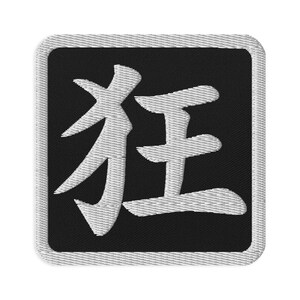 May include: A square embroidered patch featuring a black background with a white border and a large white Japanese kanji character in the center. The stitching is visible throughout the design, creating a textured appearance on the fabric surface.