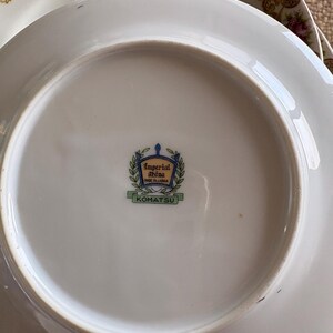 May include: White porcelain plates with floral and gold trim. The underside of the plate features the text "Imperial China Made in Japan" and the name "KOMATSU" in a green rectangle.
