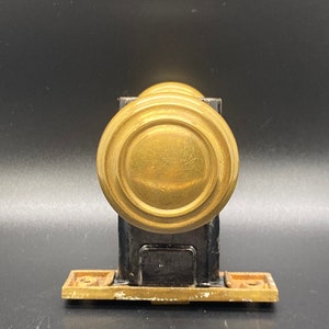 May include: A vintage brass door handle with a round knob and a rectangular base plate.