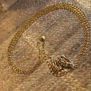Puede incluir: Un collar de cadena de oro con un par de pendientes a juego. Los pendientes tienen peque&ntilde;as piedras azules y blancas.