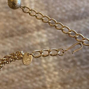 Puede incluir: Un collar de cadena de oro con un peque&ntilde;o dije redondo y un cierre de langosta. La cadena est&aacute; hecha de un dise&ntilde;o de cuerda trenzada. El dije tiene la palabra "Italia" grabada.