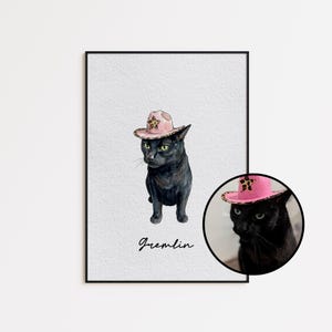 May include: A framed print featuring a black cat wearing a pink cowboy hat with a leopard print star. The word "Gremlin" is written in cursive below the cat. A smaller, circular image of the cat is in the lower right corner.