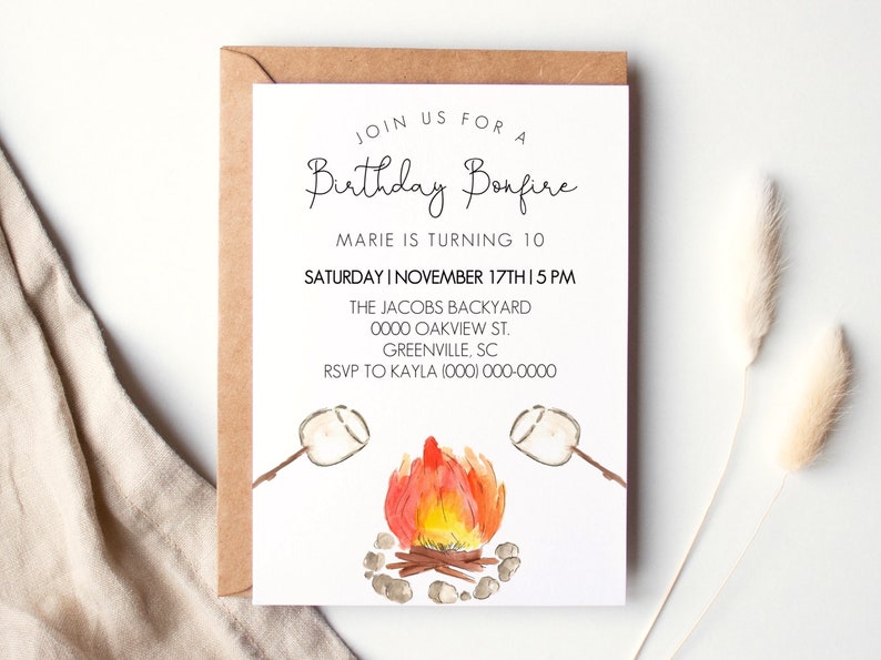 May include: A white invitation card with a watercolor illustration of a campfire with two marshmallows on sticks. The text on the card reads "Join us for a Birthday Bonfire, Marie is turning 10, Saturday I November 17th I 5 PM, The Jacobs Backyard, 0000 Oakview St., Greenville, SC, RSVP to Kayla (000) 000-0000".