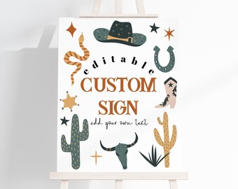 May include: A white sign on an easel with a western theme. The sign features illustrations of a cowboy hat, snake, cactus, horseshoe, and a steer skull. The text reads "editable CUSTOM SIGN add your own text."