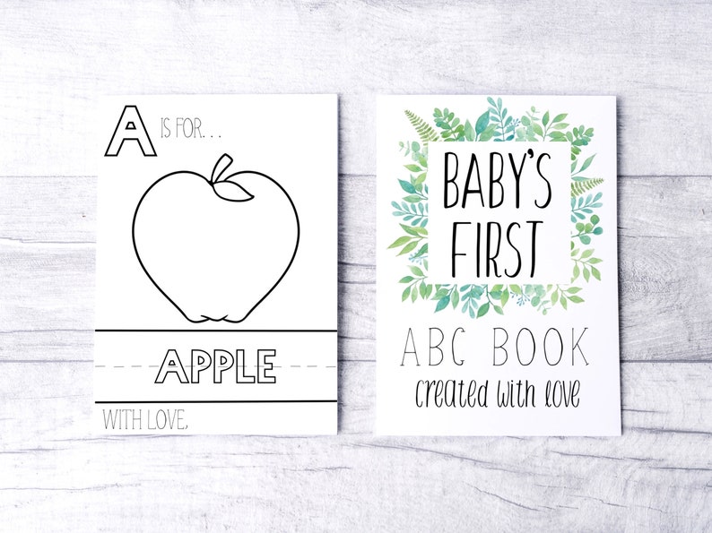 Może przedstawiać: Dwie ilustrowane karty. Jedna przedstawia duży kontur jabłka ze słowem "APPLE" poniżej i tekstem "A is for..." powyżej. Druga karta m&oacute;wi "BABY'S FIRST ABC BOOK created with love" otoczona zielonymi liśćmi.