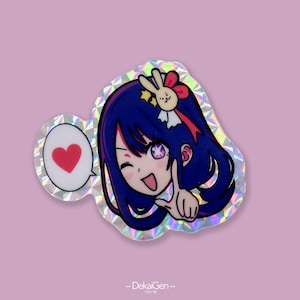 May include: A holographic sticker featuring a cartoon character with blue hair, a pink bow, and a heart-shaped speech bubble. The character is winking and pointing with one finger.