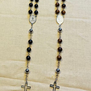 Rosary wood and stainless steel. Waxed natural wood bead and ebony with stainless steel beads and simple stainless steel cross