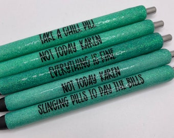 Puede incluir: Cinco bolígrafos brillantes de color turquesa con texto negro. Los bolígrafos tienen frases como "TAKE A CHILL PILL" y "NOT TODAY KAREN". Los bolígrafos tienen puntas plateadas y tinta negra. Adecuado para regalos o papelería.