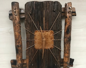 May include: A rustic wooden clock with a copper face and gold-colored hands. The clock is mounted on a piece of reclaimed wood with two wooden posts on either side.