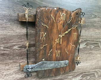 May include: A rustic wooden clock with Roman numeral markings and gold-colored hands. The clock is mounted on a piece of reclaimed wood with a metal latch and barbed wire accents.