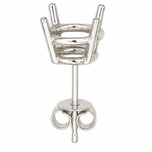 May include: A silver-toned metal earring setting featuring a four-prong basket design intended to hold a gemstone. The component includes a straight post and a circular friction back closure with two coiled loops for secure attachment to the ear.