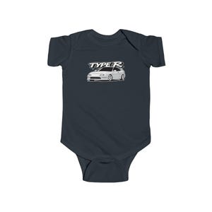 May include: Dark navy blue baby bodysuit featuring a white car graphic and the text "TYPE R". The car is a white coupe, illustrated in detail. The bodysuit is made of soft material, suitable for a baby.