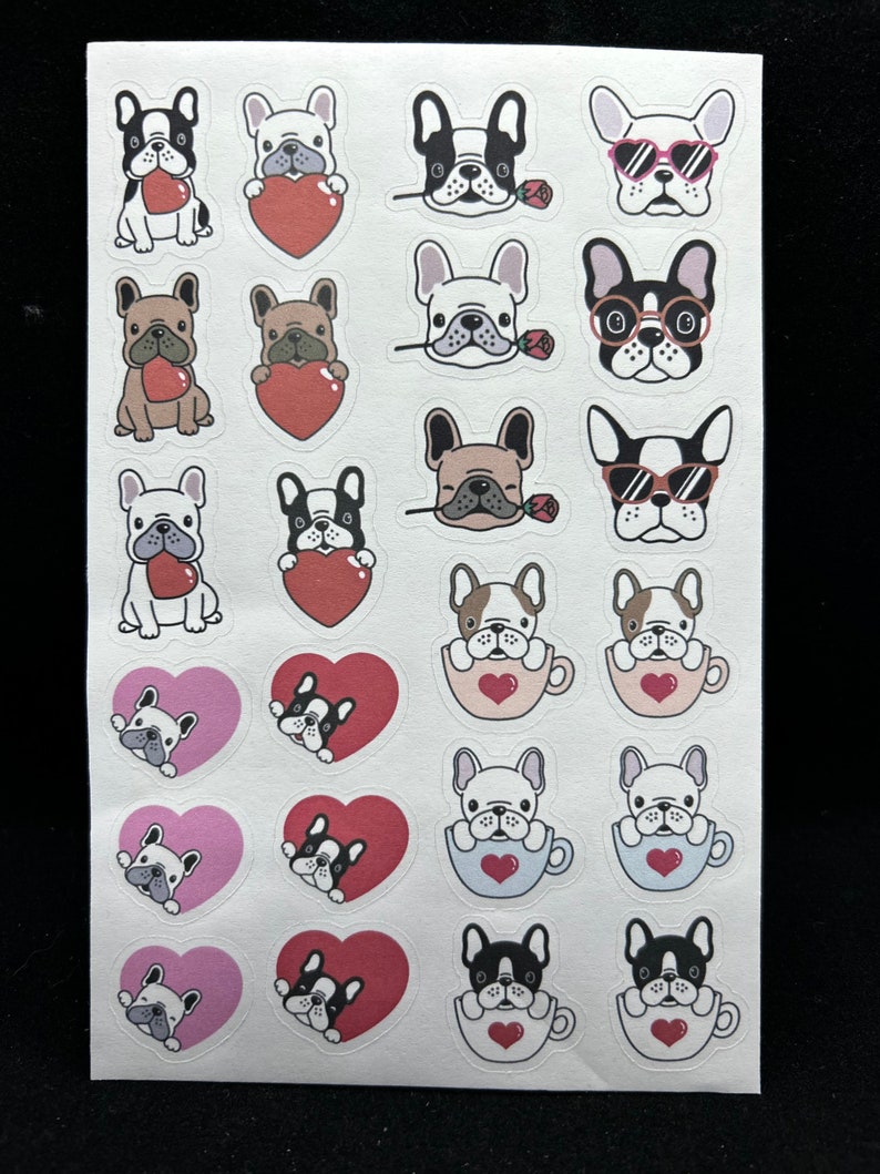 May include: A sheet of stickers featuring various illustrations of French Bulldogs. The stickers depict the dogs in different poses, including holding hearts, wearing sunglasses, and sitting in teacups. The stickers are printed on white paper with a glossy finish.