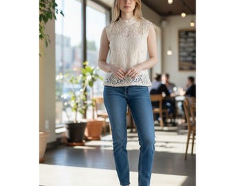 Nannette? Top sin mangas de encaje color marfil con cuello alto y diseño de estampado floral.