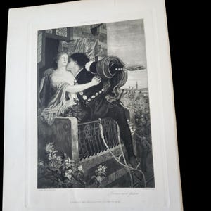 May include: A black and white print of a romantic scene from Shakespeare's "Romeo and Juliet." The image depicts a man kissing a woman on a balcony, with a cityscape visible in the background. The print is framed and mounted on a white background.