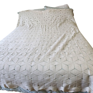 May include: A white crocheted bedspread with a geometric pattern of squares and diamonds.