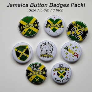 May include: A set of seven round Jamaica button badges. Each badge displays the Jamaican flag colours: green, yellow, and black. Some badges feature the word "Jamaica", a lion, or the number "62". The badges are 7.5 cm in diameter.