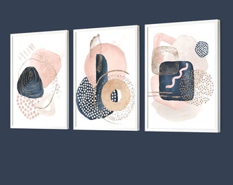 May include: Three framed abstract art prints featuring pink and blue watercolour shapes with gold accents. The prints are in white frames and are arranged in a row.