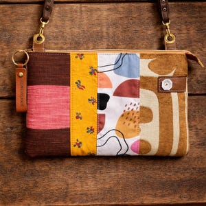 Bolso bandolera patchwork: tejidos y cuero reciclados, correa ajustable.