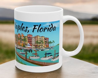 Puede incluir: Taza de cerámica blanca con una ilustración colorida de una escena de la costa en Naples, Florida. La ilustración presenta edificios, barcos y un muelle. El texto "Naples, Florida" está impreso en negro en la taza.