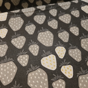 May include: Black fabric with a repeating pattern of white and gray strawberries with gold accents.