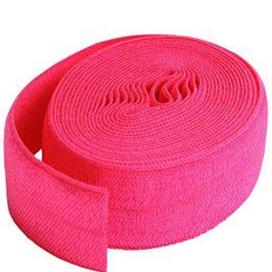 May include: A roll of bright pink elastic ribbon. The ribbon is tightly wound, revealing a textured surface. The vibrant color and flexible material suggest its use in crafting or apparel.