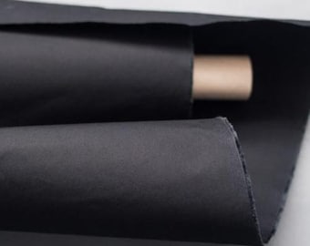 May include: A roll of black fabric is folded in half, with one end of the roll visible. The fabric is smooth and has a slight sheen.