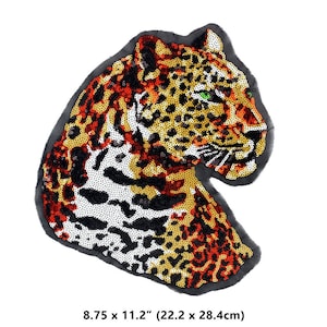 Può includere: Un toppa termoadesiva con la testa di un leopardo, realizzata con paillettes nere, arancioni e bianche. La toppa misura 8,75 pollici per 11,2 pollici (22,2 cm per 28,4 cm).