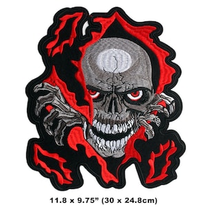 May include: Embroidered patch depicting a fearsome skull with red eyes and a wide grin, breaking through a torn black and red backdrop. The patch measures 30 x 24.8cm.