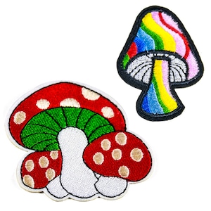 May include: Two embroidered iron-on patches featuring mushroom designs. One patch is a red and white mushroom with green gills. The other patch is a rainbow-colored mushroom with a white stem.