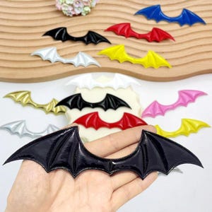 Może przedstawiać: Biały ceramiczny kubek z czarnym uchwytem i napisem "But First, Coffee" pogrubioną czcionką. Kubek jest umieszczony na rozmytym tle, sugerującym przytulne otoczenie.