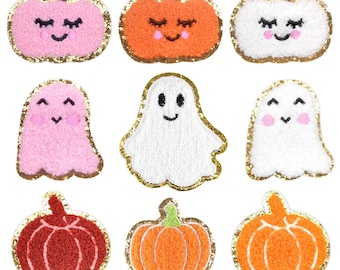 Könnte beinhalten: Neun Filz-Aufnäher zum Thema Halloween. Es gibt drei rosa Geister, drei orangefarbene Kürbisse und drei rote Kürbisse. Jeder Aufnäher hat einen goldenen Glitzer-Umrandung.
