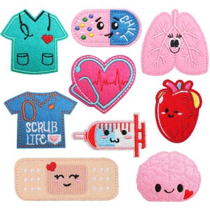May include: A collection of colorful felt patches with medical themes. Includes patches shaped like scrubs, a pill, lungs, a heart with a stethoscope, a syringe, a heart, a bandage, and a brain. Each patch has a cute, cartoon-like design.