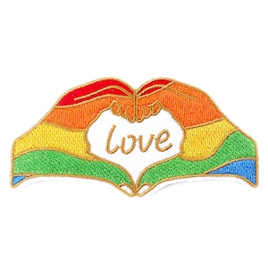 Può includere: Toppa ricamata con due mani che formano un cuore a forma di arcobaleno. La parola "love" è scritta in oro all'interno del cuore.