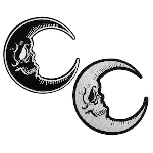May include: Two black and white embroidered iron-on patches of a crescent moon with a skull inside.