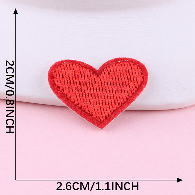 May include: Red felt heart-shaped patch, measuring 2.6 inches wide and 0.8 inches tall.