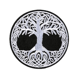 Op de afbeelding: Wit geborduurde levensboom patch op een zwarte vilt achtergrond. De boom is omgeven door een cirkelvormig ontwerp van verweven takken.