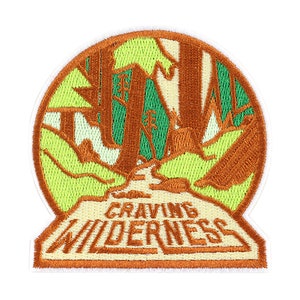 May include: An embroidered patch with a green and brown forest scene and the text "CRAVING WILDERNESS".