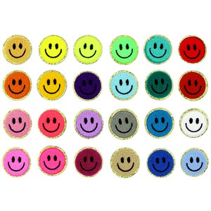 Op de afbeelding: Een verzameling van vierentwintig ronde patches gerangschikt in vier rijen. Elke patch heeft een getextureerd, pluizig smileygezicht in een unieke effen kleur, waaronder tinten geel, rood, blauw, roze, groen, paars, grijs en wit, allemaal met een gouden rand.